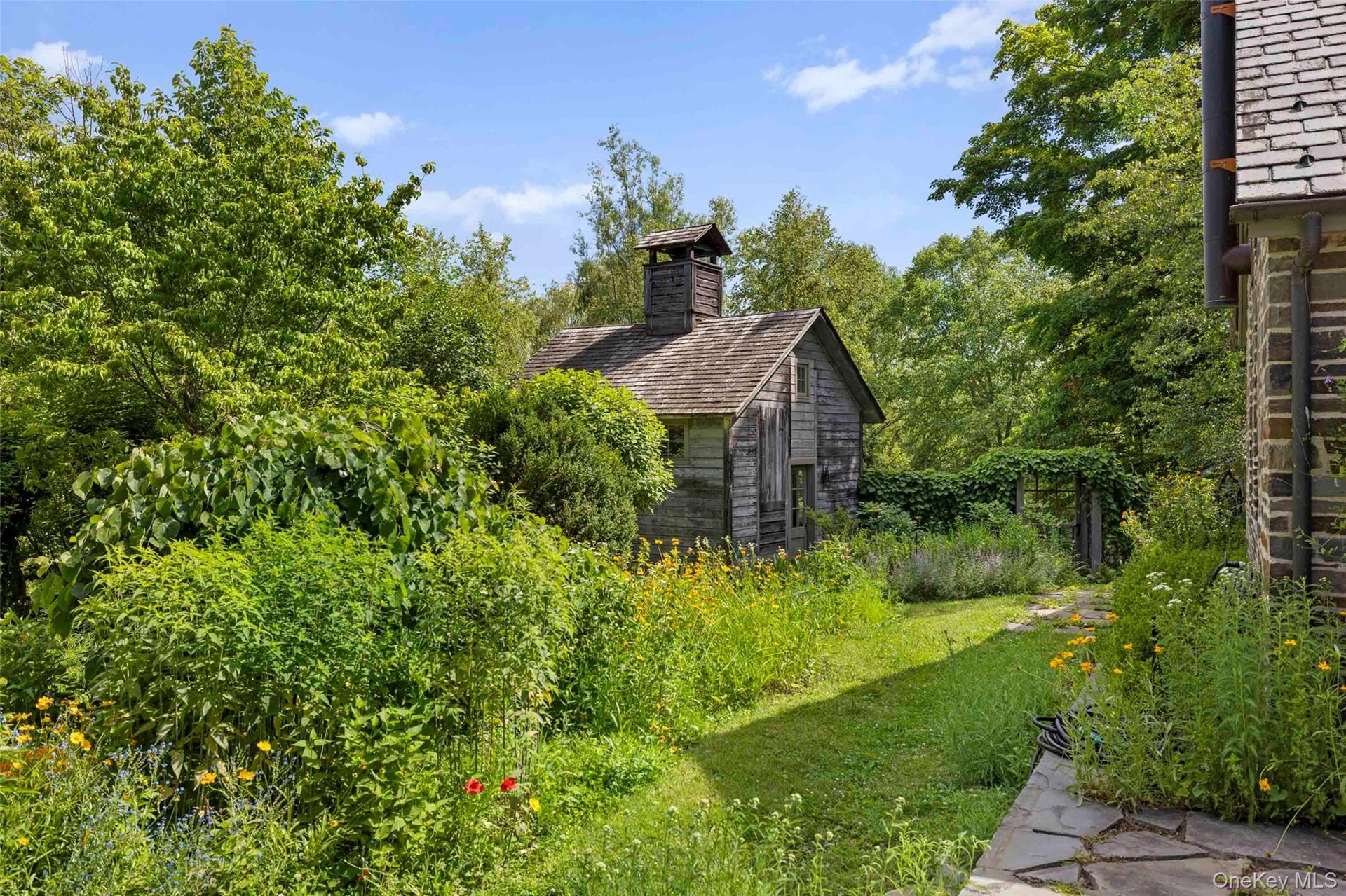 A tranquil garden setting surrounds the wellness studio, creating a peaceful connection with nature