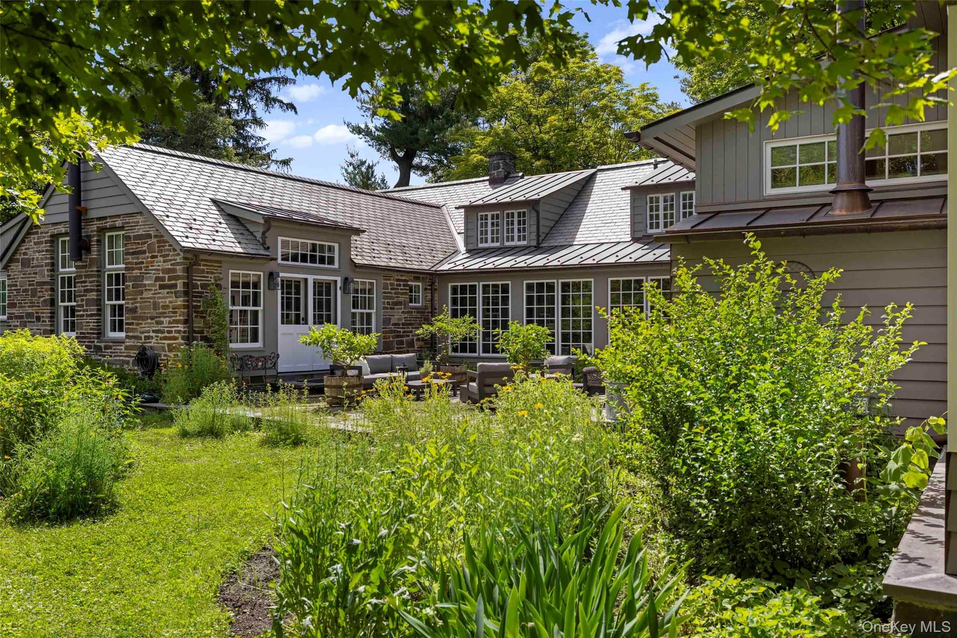 An inviting outdoor space with views across the surrounding gardens, thoughtfully positioned between the home’s east and west wings