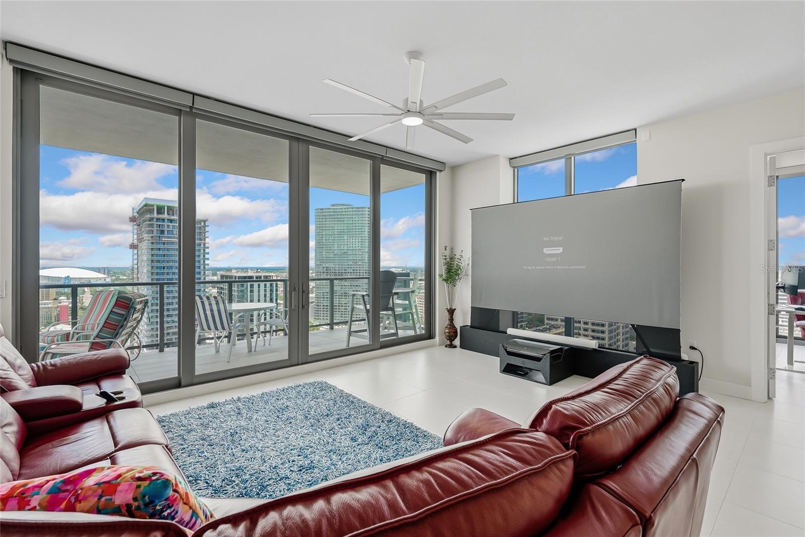 “smart” family room features a comfortable leather sofa with three motorized loungers, a 120” state-of-the-art projection TV that rises from the floor
