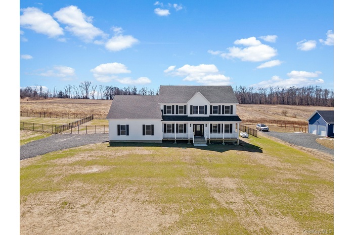 View of front facade with roof with shingles, a view of countryside, and gravel driveway