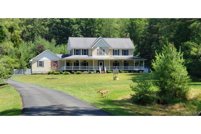 Traditional-style residence featuring a broad wrap-around porch and a gabled roofline