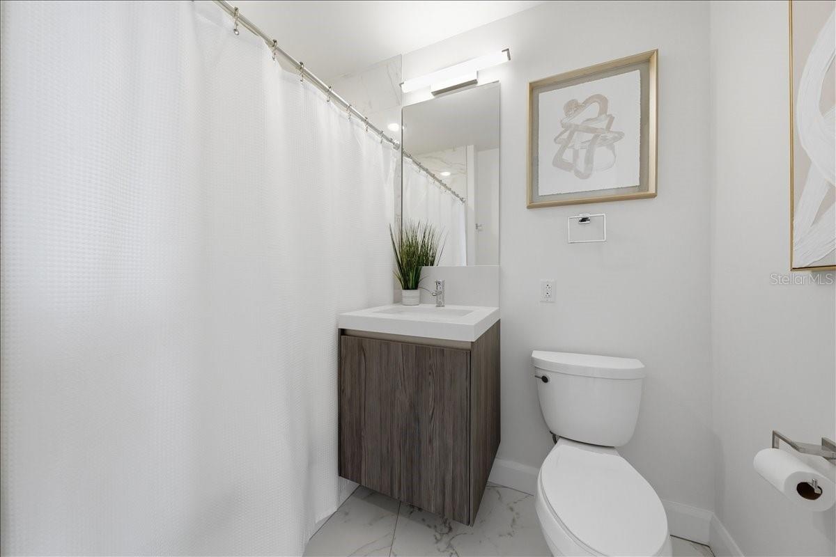 Well-appointed secondary bathroom with stone finishes.