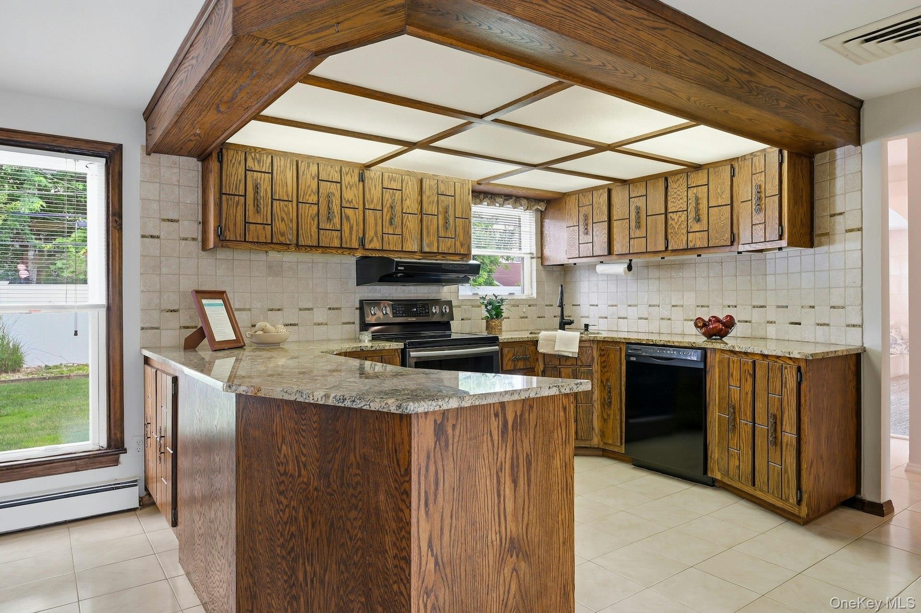 Kitchen featuring wood-finish cabinetry, light-toned tiled backsplash, and granite-style countertops