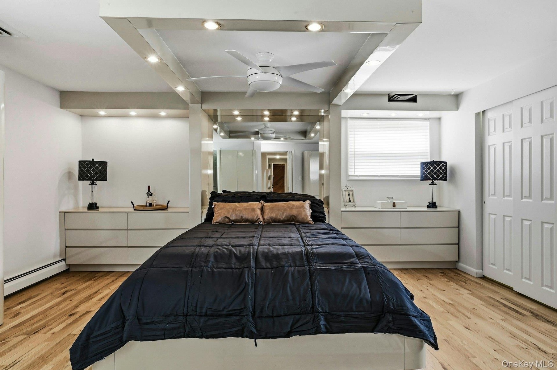 Recessed lighting accentuates the tray ceiling with a built-in ceiling fan