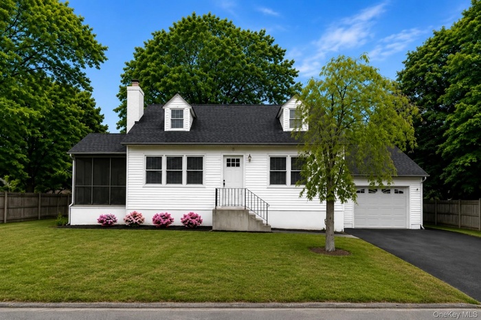 Lovely Cape Cod home with semi attached garage with power door opener freshly paved driveway and mature trees