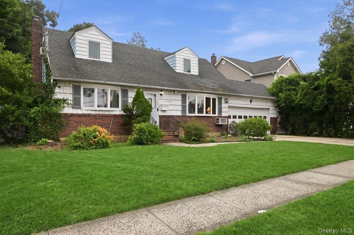 Traditional style residence featuring a brick and siding facade with dormer windows