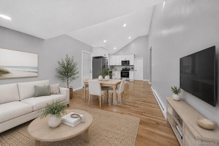 Open-concept living space featuring vaulted ceilings and wood-finish flooring