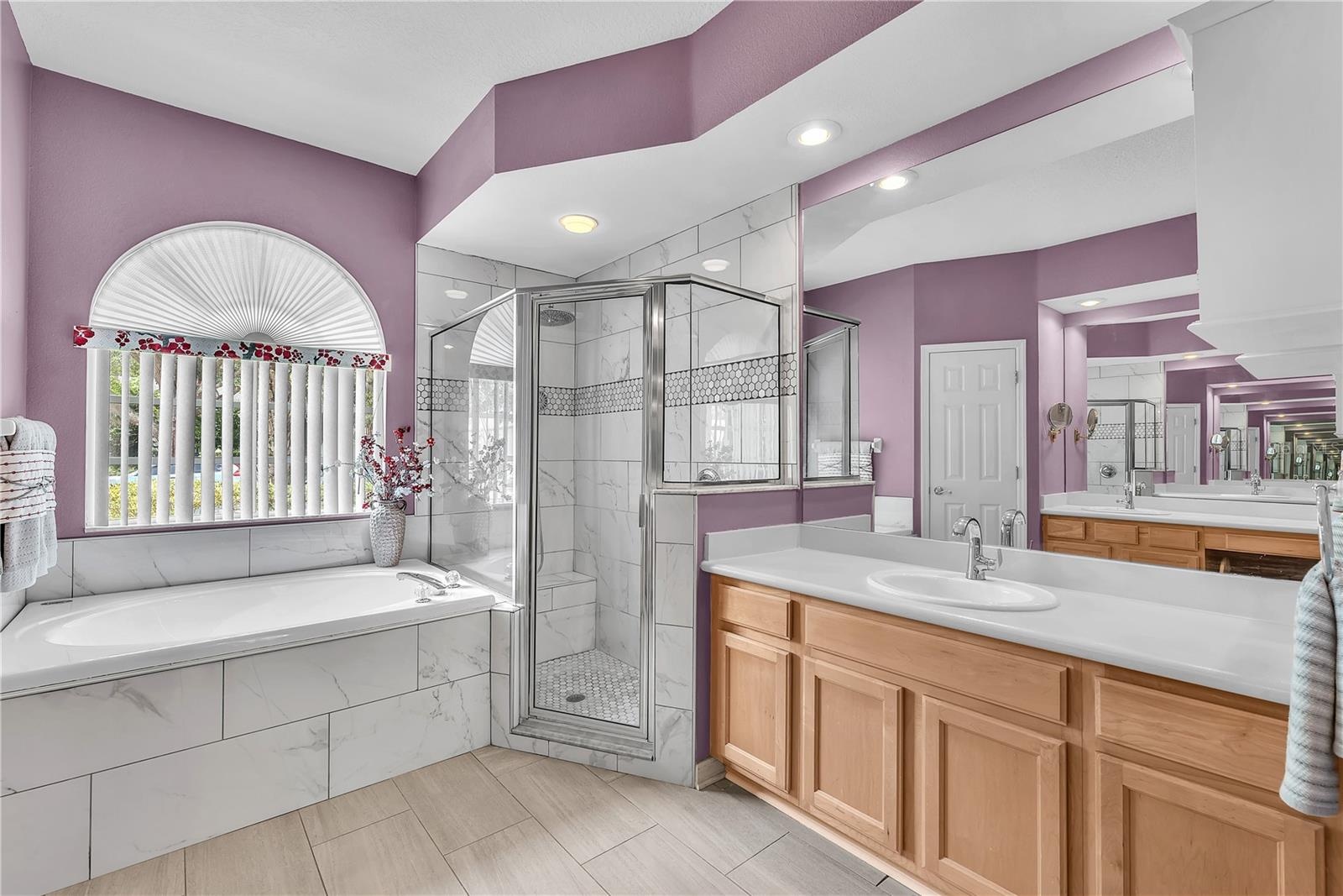 The walk-in shower has a rain head fixture and a built-in seat.