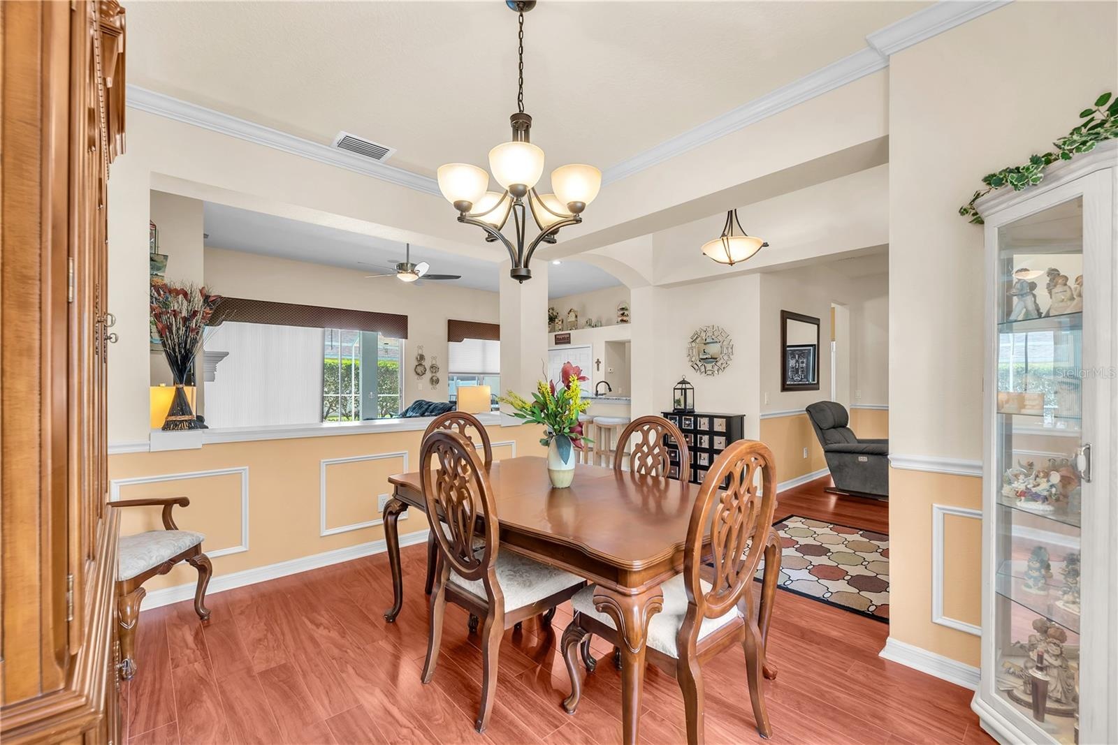 A large architectural opening between the dining room and family room enhances the home's open feel while maintaining distinct gathering spaces.