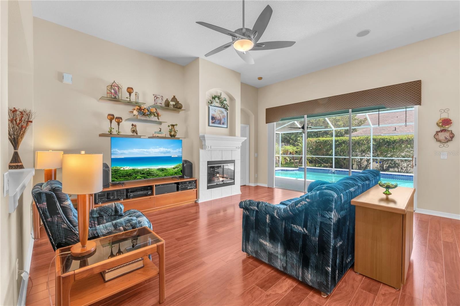 The expansive family room showcases beautiful flooring, wood burning fireplace and triple sliding glass doors that fully open to your own private back