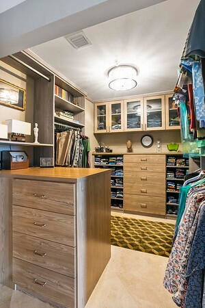 Primary WIC w/ custom bulitouts for maximum storage & glass face upper cabinets