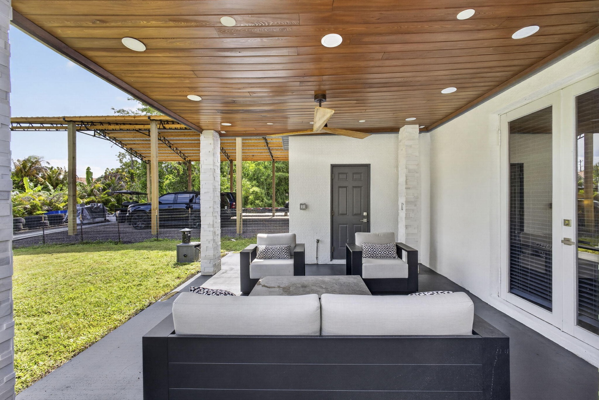 OUTDOOR PATIO WITH CABANA BATH BEHIND DOOR AHEAD