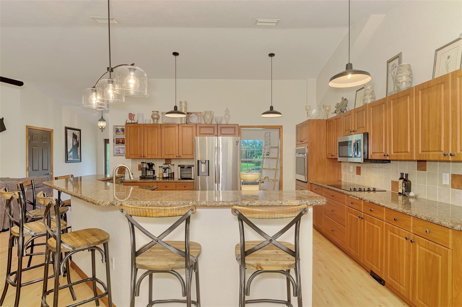Granite counters and tile backsplash and upgraded lighting in the kitchen