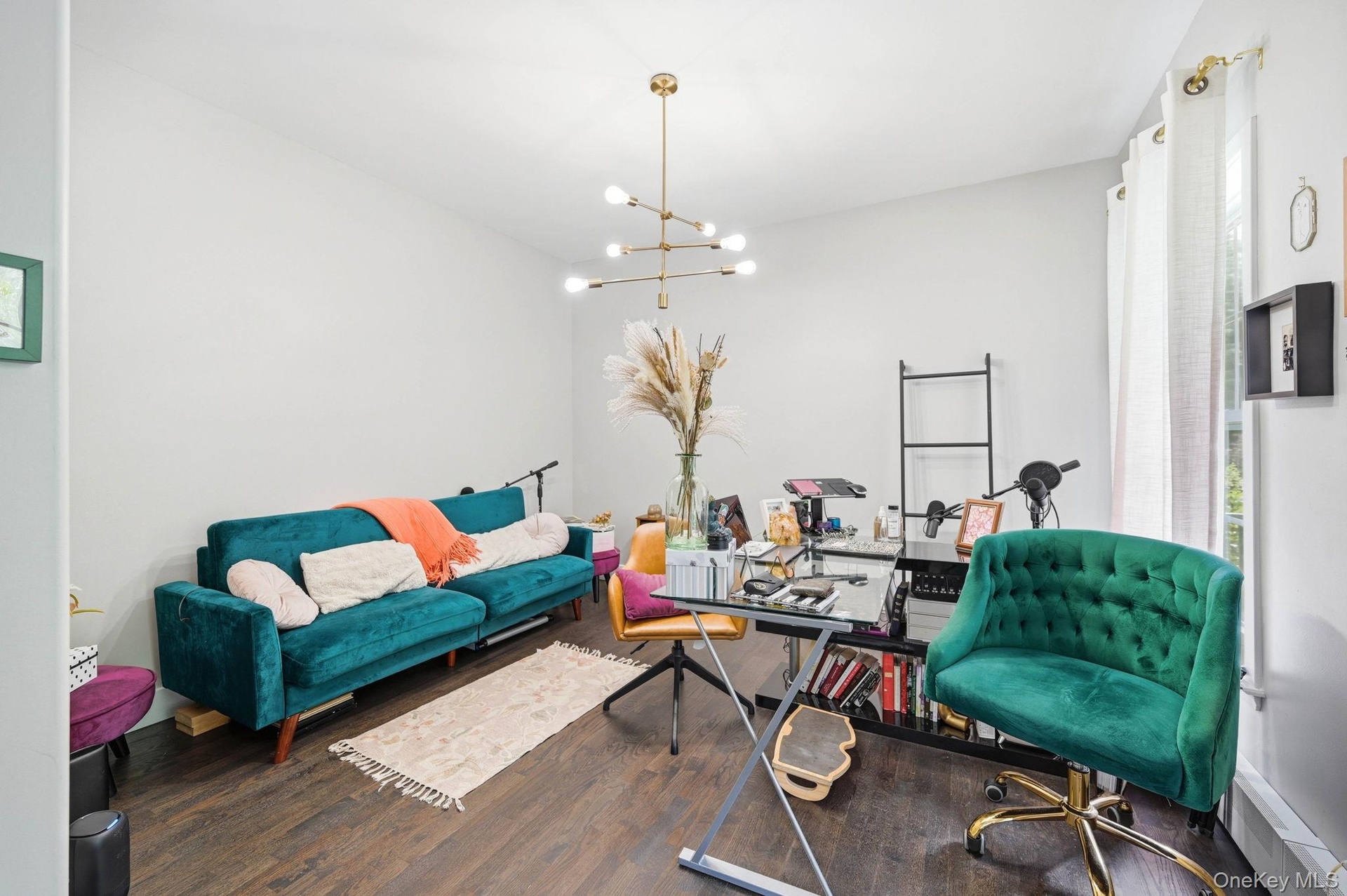 Spacious room featuring wood-finish flooring and a contemporary multi-arm chandelier
