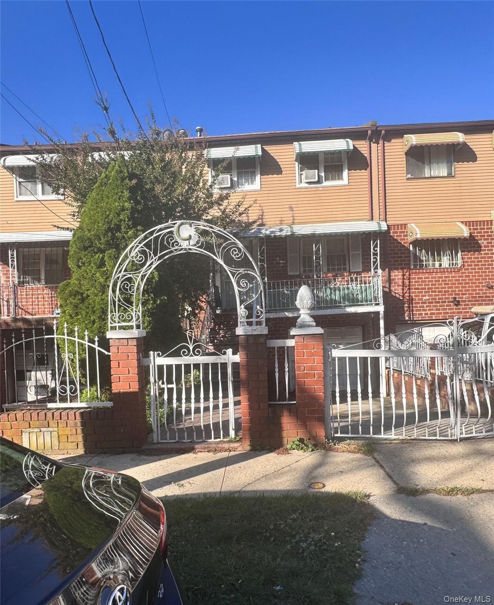 View of front of house featuring a fenced front yard, a gate, and brick siding