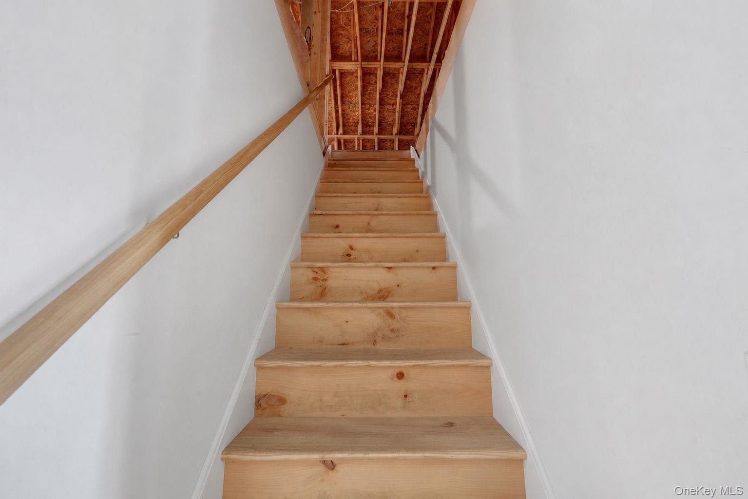 Staircase into attic with large storage area.