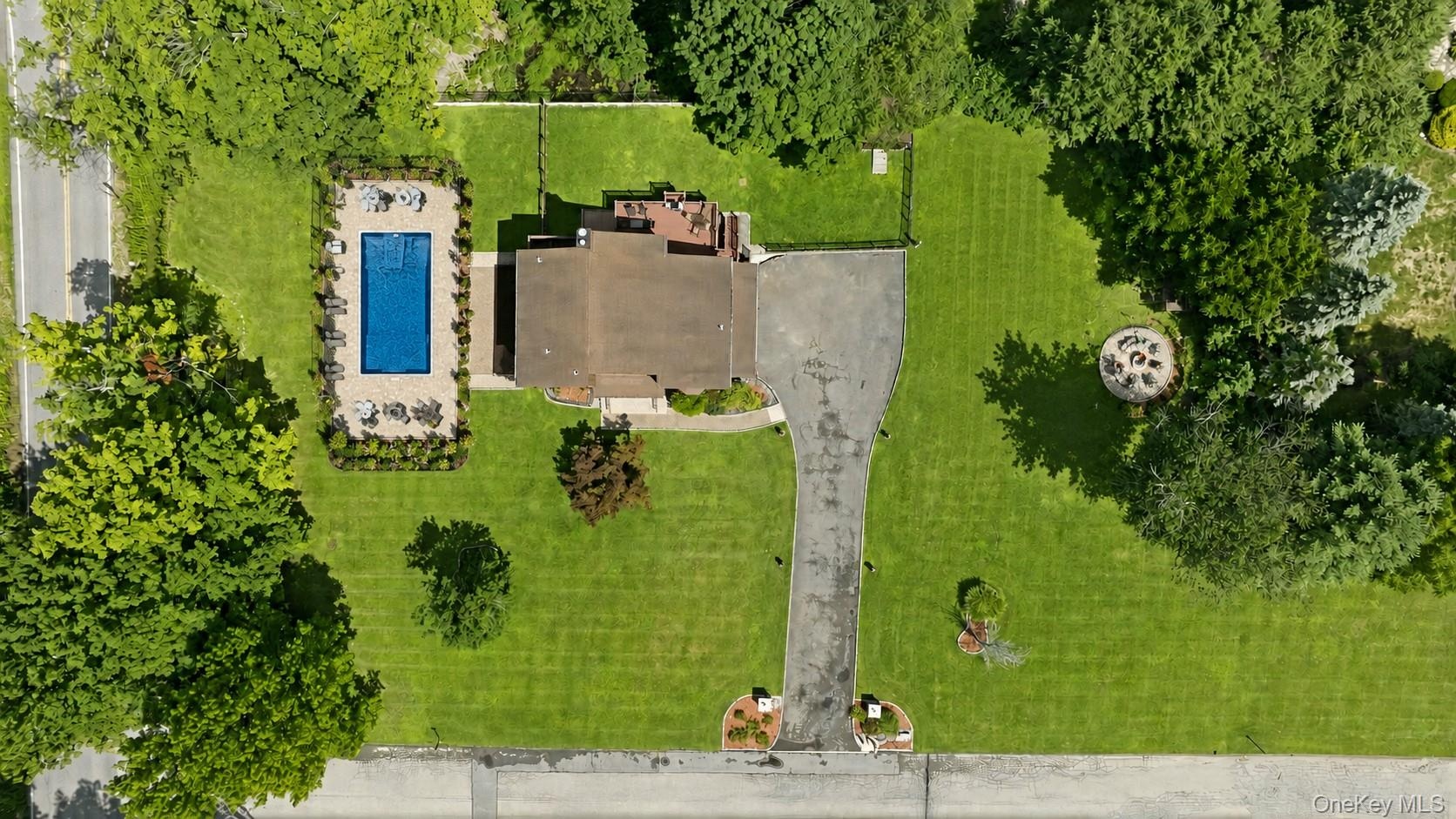 Aerial view showcasing a virtually staged large pool and patio.  Massive yard can be a new owners playground and sactuary!