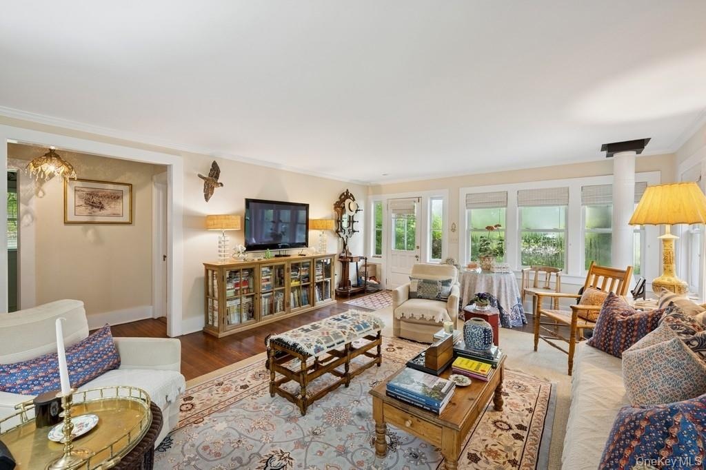Living room with ornamental molding and wood finished floors