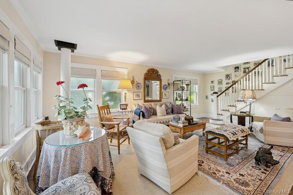 Living area with stairway and ornamental molding