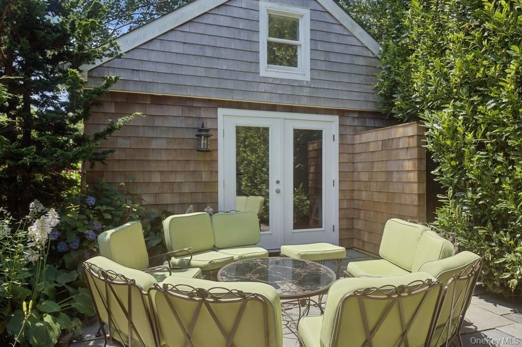 View of pool house with bathroom featuring french doors and outdoor lounge area