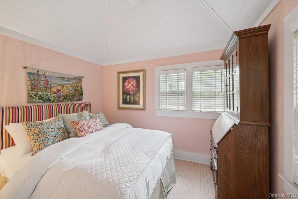 Bedroom with vaulted ceiling, wood ceiling, and light carpet