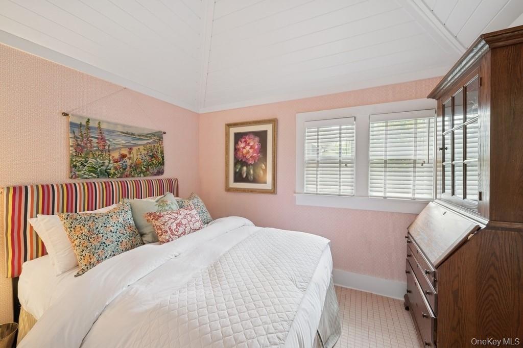 Carpeted bedroom featuring lofted ceiling and baseboards
