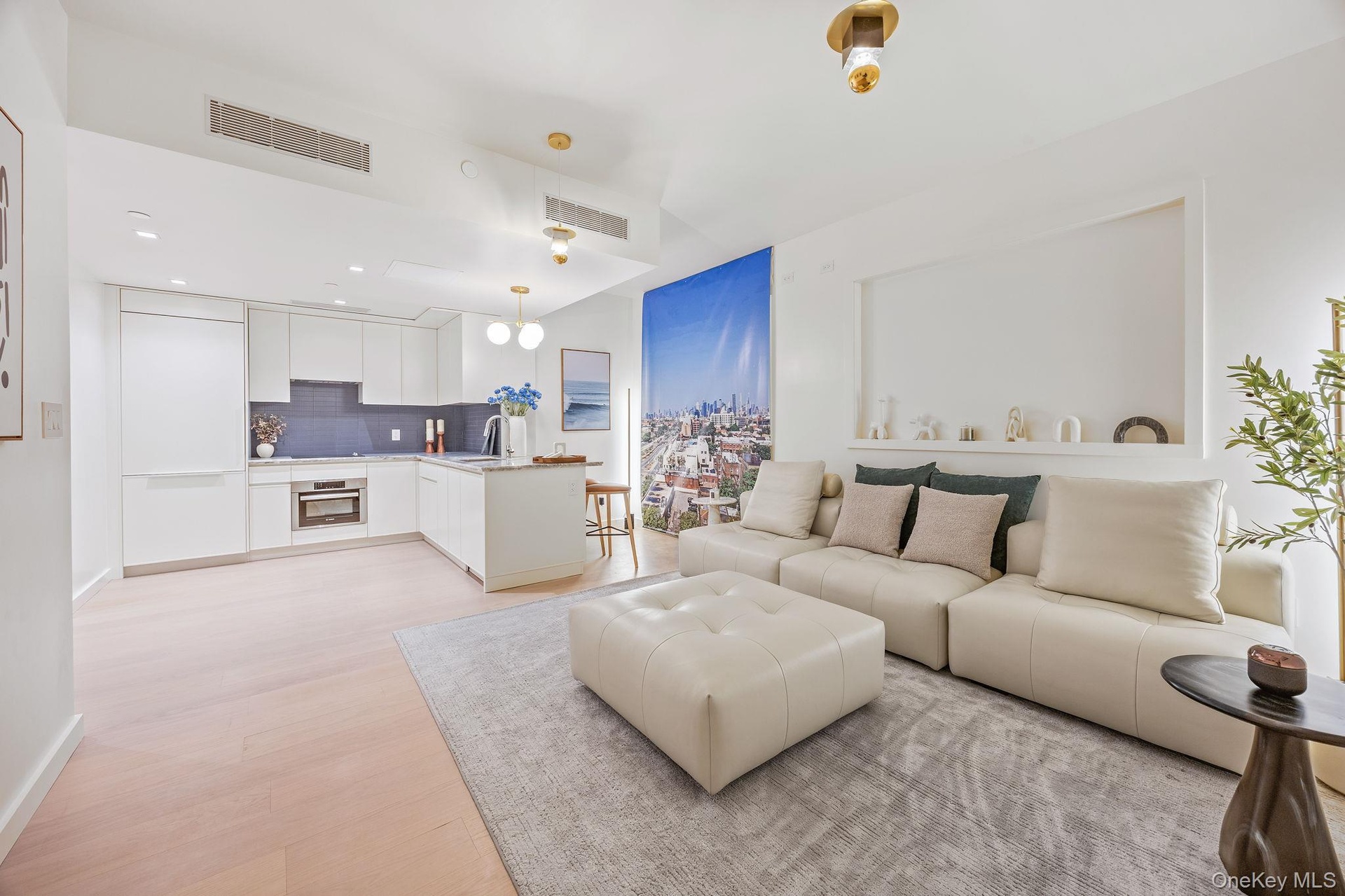 Living area with light wood finished floors and recessed lighting