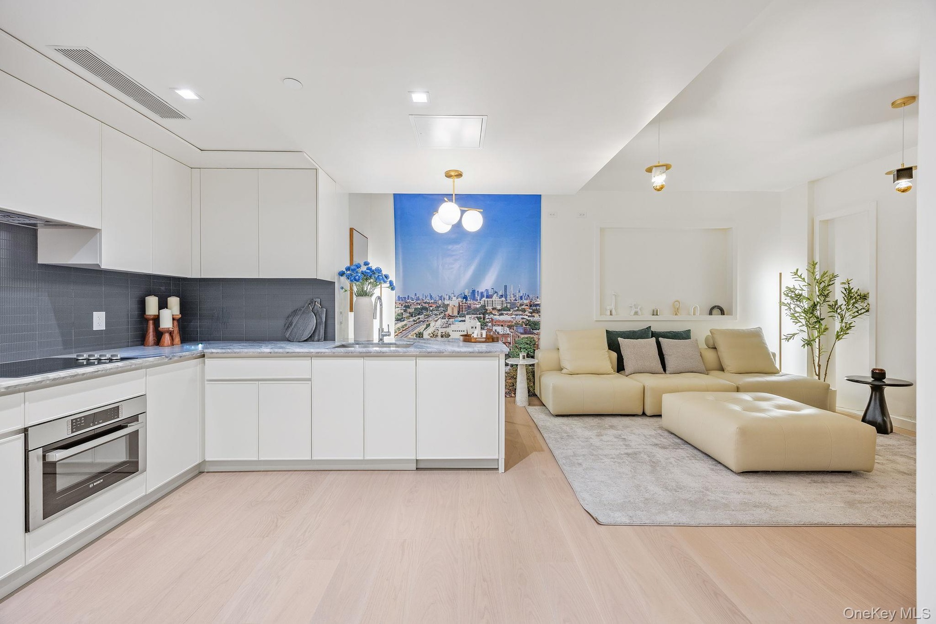 Kitchen with modern cabinets, stainless steel oven, white cabinets, and hanging light fixtures