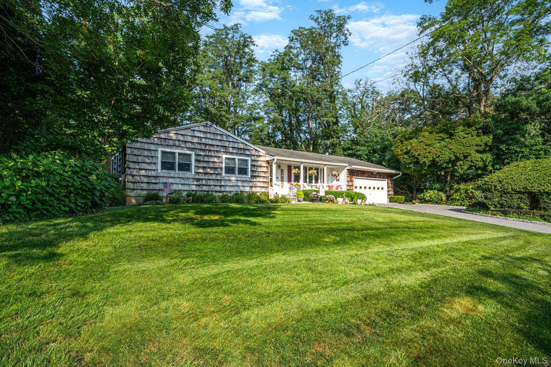 Single-story residence featuring shingle siding and a white garage door