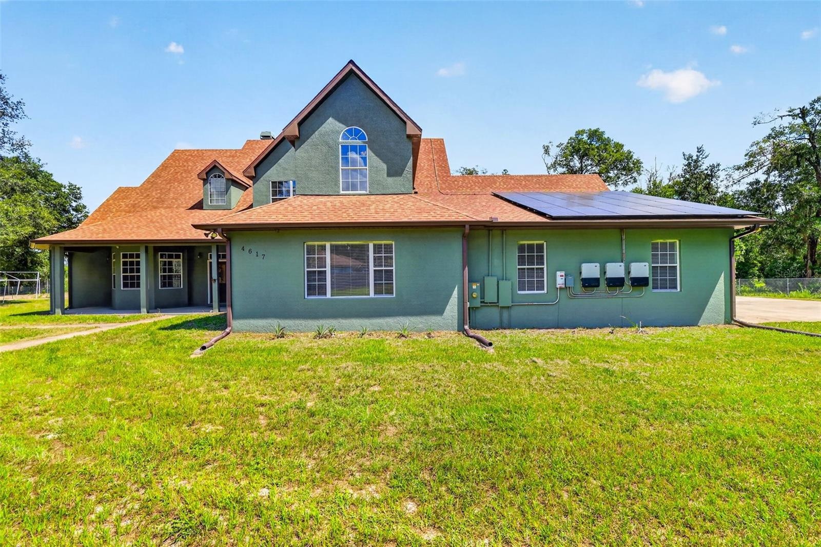 Welcome to 4617 Round Lake Rd: a custom two-story home on sprawling acreage in Apopka with owned solar panels and timeless curb appeal.