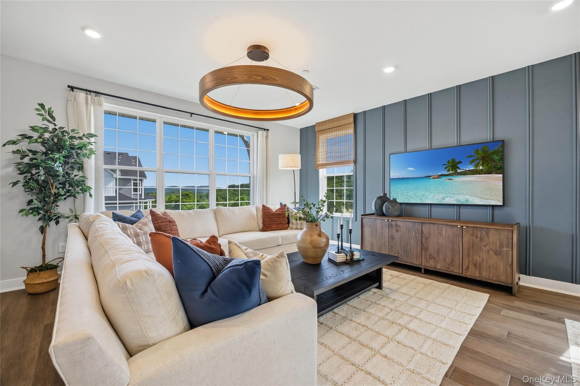 Spacious living area featuring large windows with wood-finish flooring.