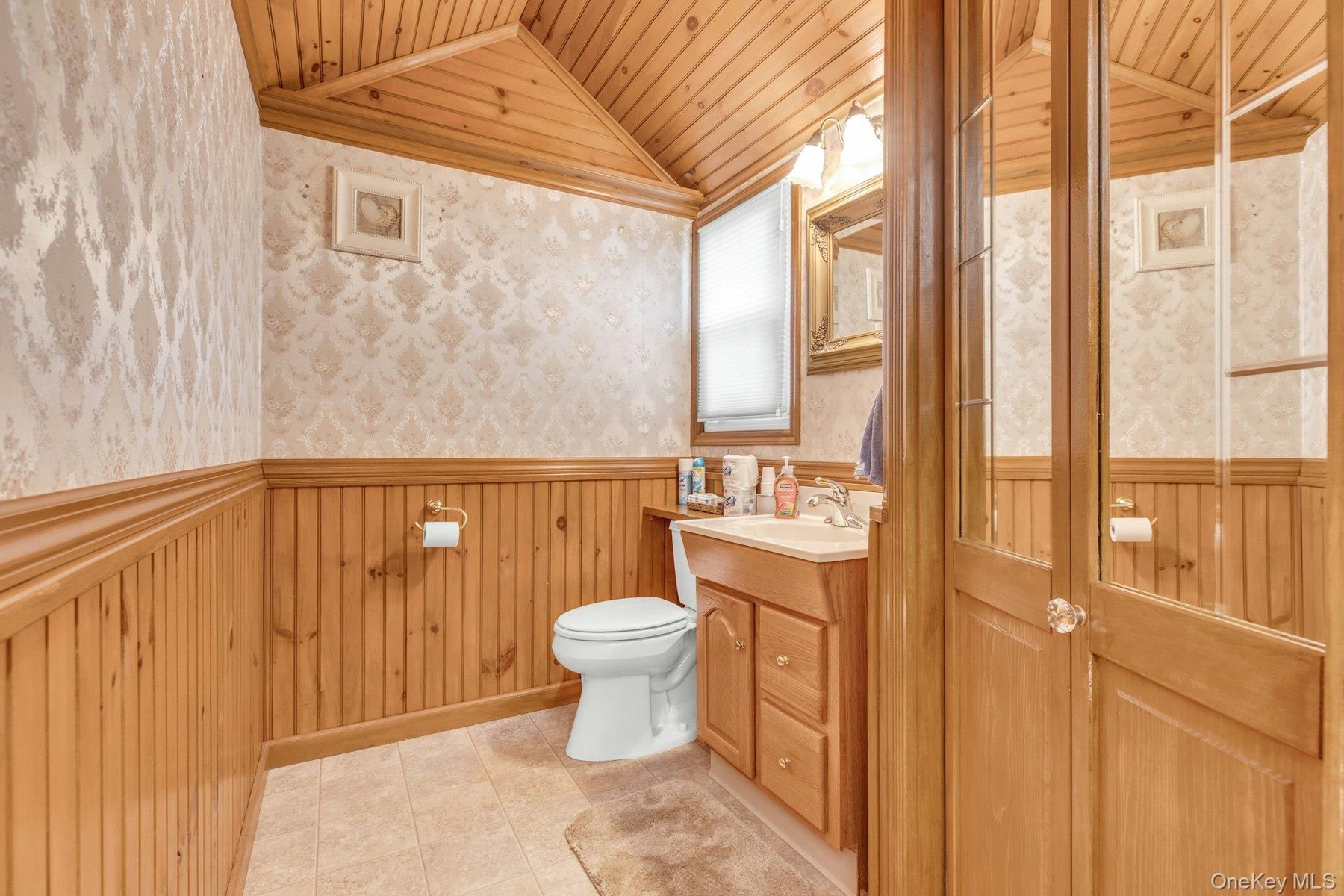Bathroom featuring a paneled wood ceiling and wainscoting