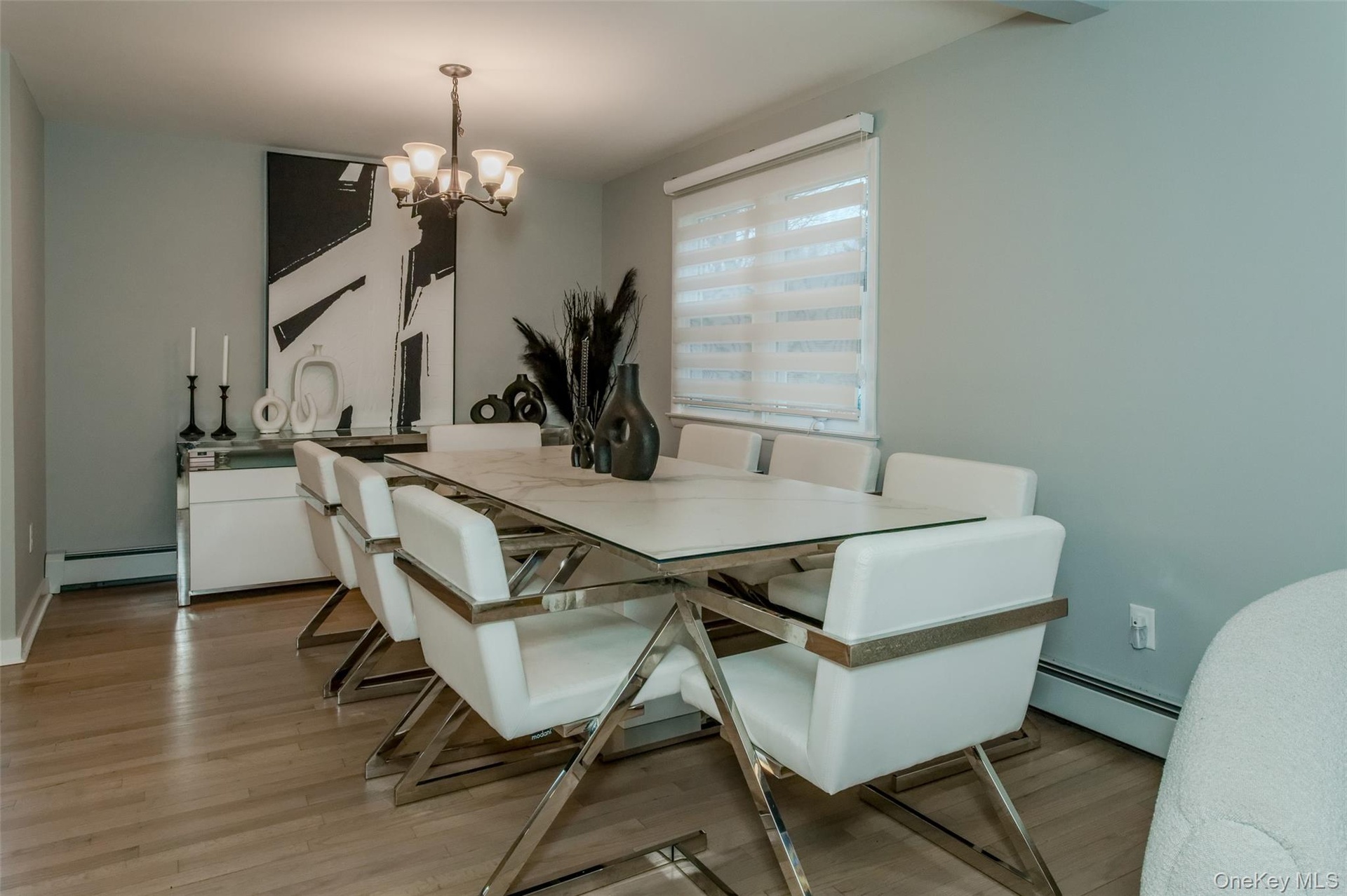 Dining space with a chandelier, a baseboard radiator, and light hardwood / wood-style floors
