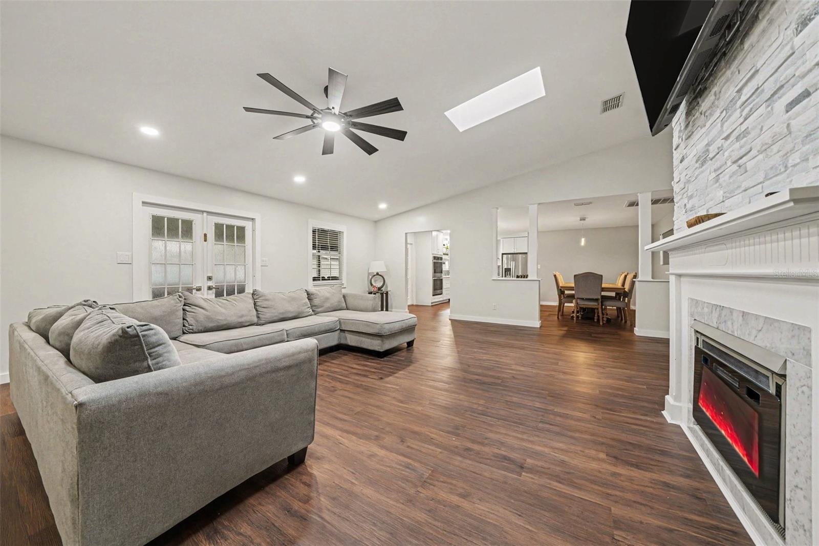 Spacious Family Room featuring Electric Fireplace & Stone tile accent wall