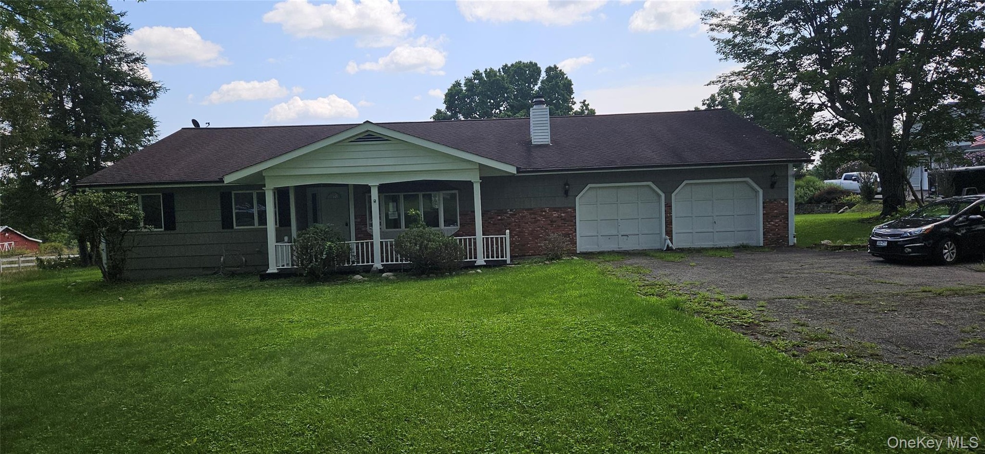 Ranch-style residence featuring a covered front porch, a two-car attached garage, and a brick facade accent