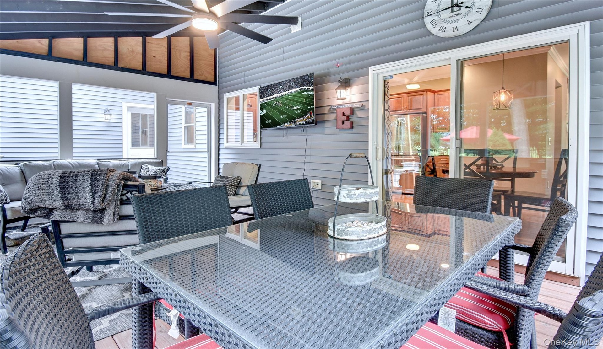 Screened porch featuring a vaulted ceiling with exposed beams, wood-finish flooring, and a ceiling fan