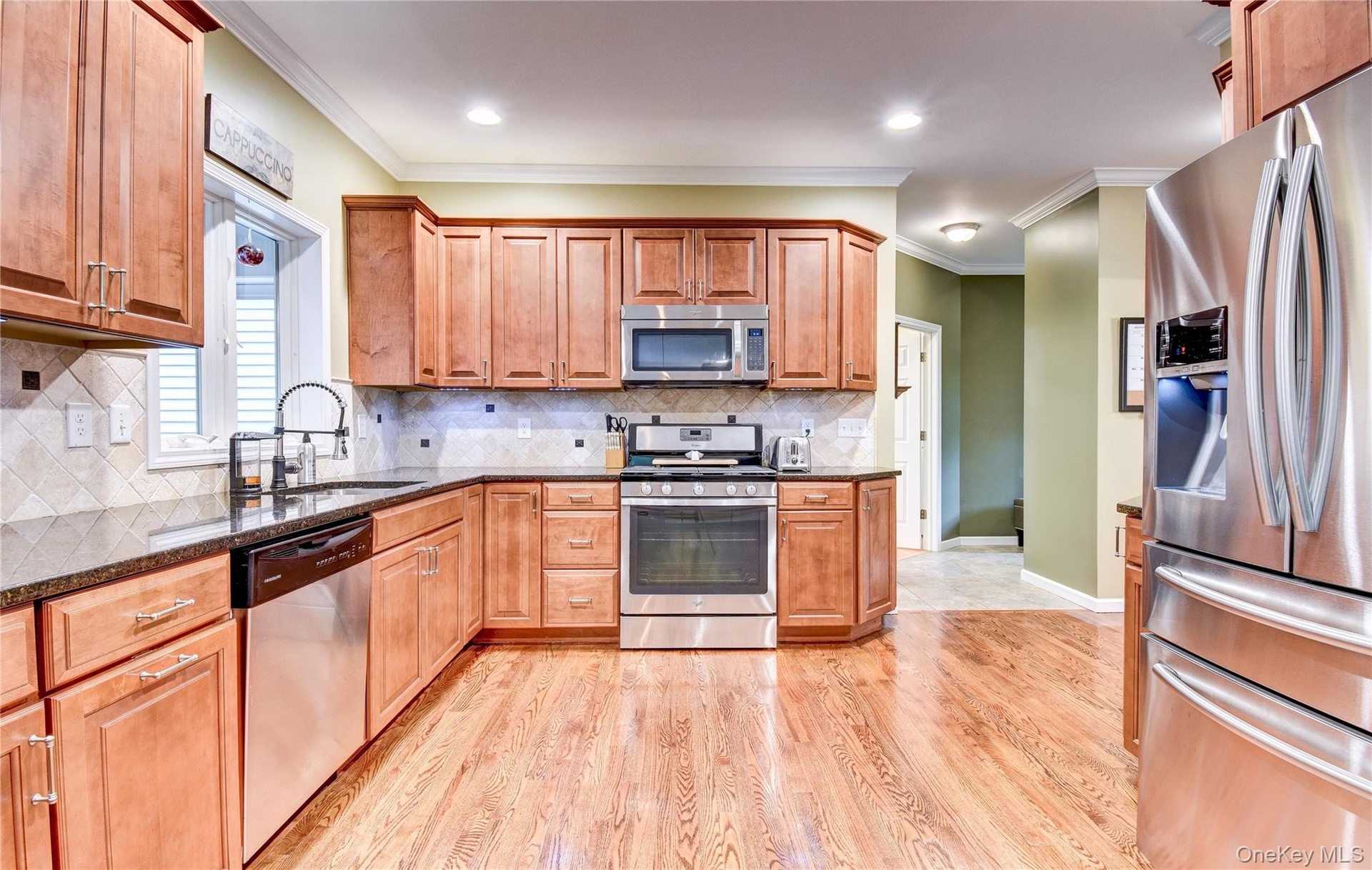 Kitchen featuring wood flooring, recessed lighting, granite counters, and crown molding