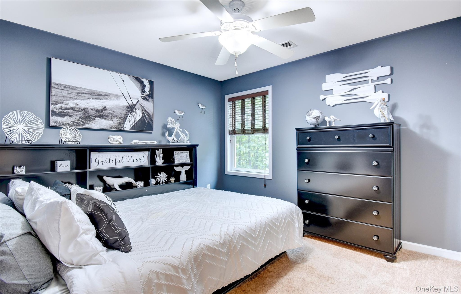 Carpeted bedroom featuring a ceiling fan with integrated lighting, and a window with blinds