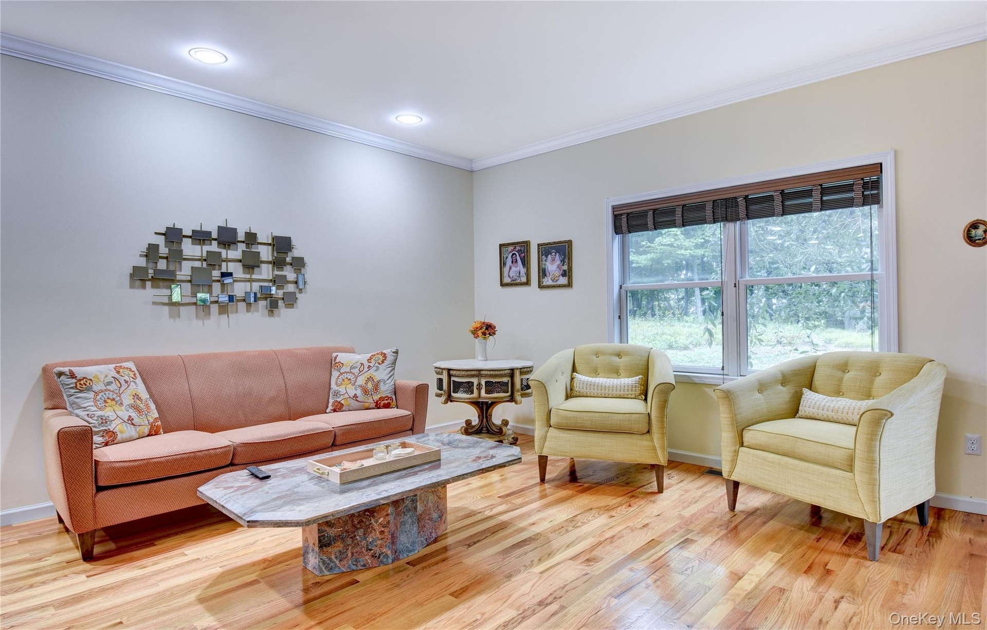 Legal accessory apartment: Bright living space featuring hardwood flooring, crown molding, recessed lighting, and a large window