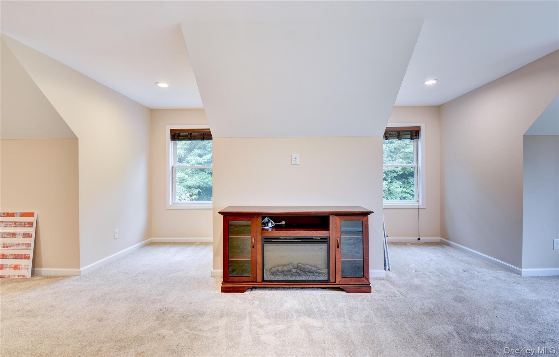 Carpeted bonus room with sloped ceilings and recessed lighting