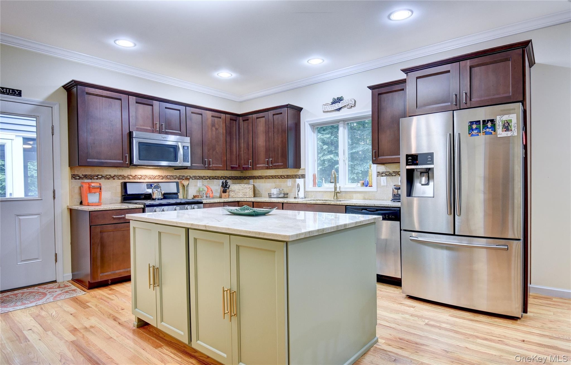 Legal accessory apartment: Kitchen featuring wood flooring, a central island with quartz countertop, dark wood upper and lower cabinetry, stainless st
