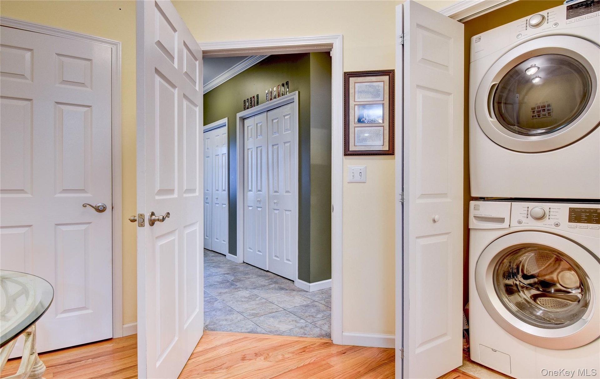 Legal accessory apartment: laundry area featuring a stacked washer and dryer unit