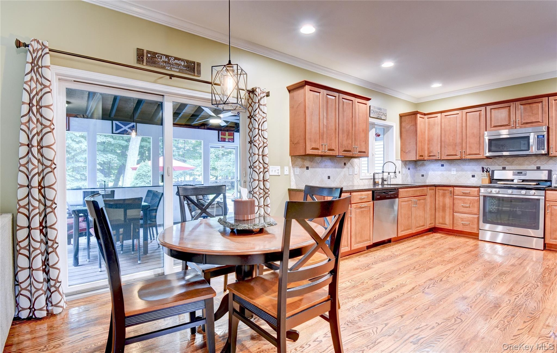 Kitchen with wood flooring, recessed lighting, and a sliding glass door opening to an enclosed porch
