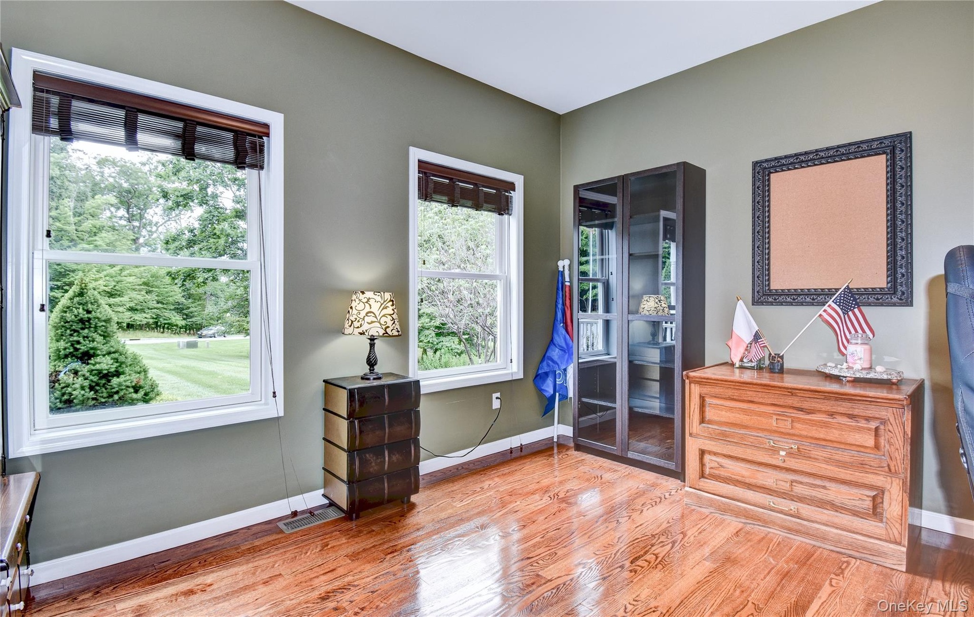 Office featuring wood flooring, two windows and french doors
