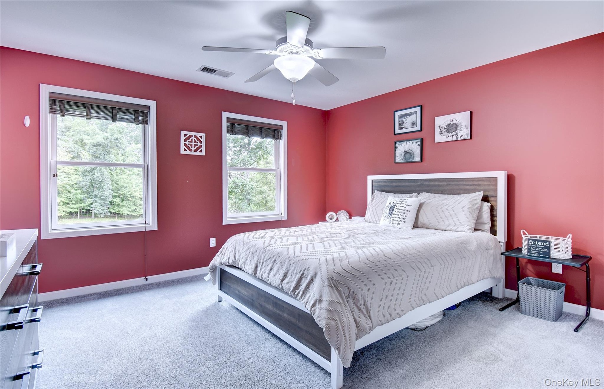 Spacious bedroom featuring neutral-toned carpet, a ceiling fan with integrated lighting