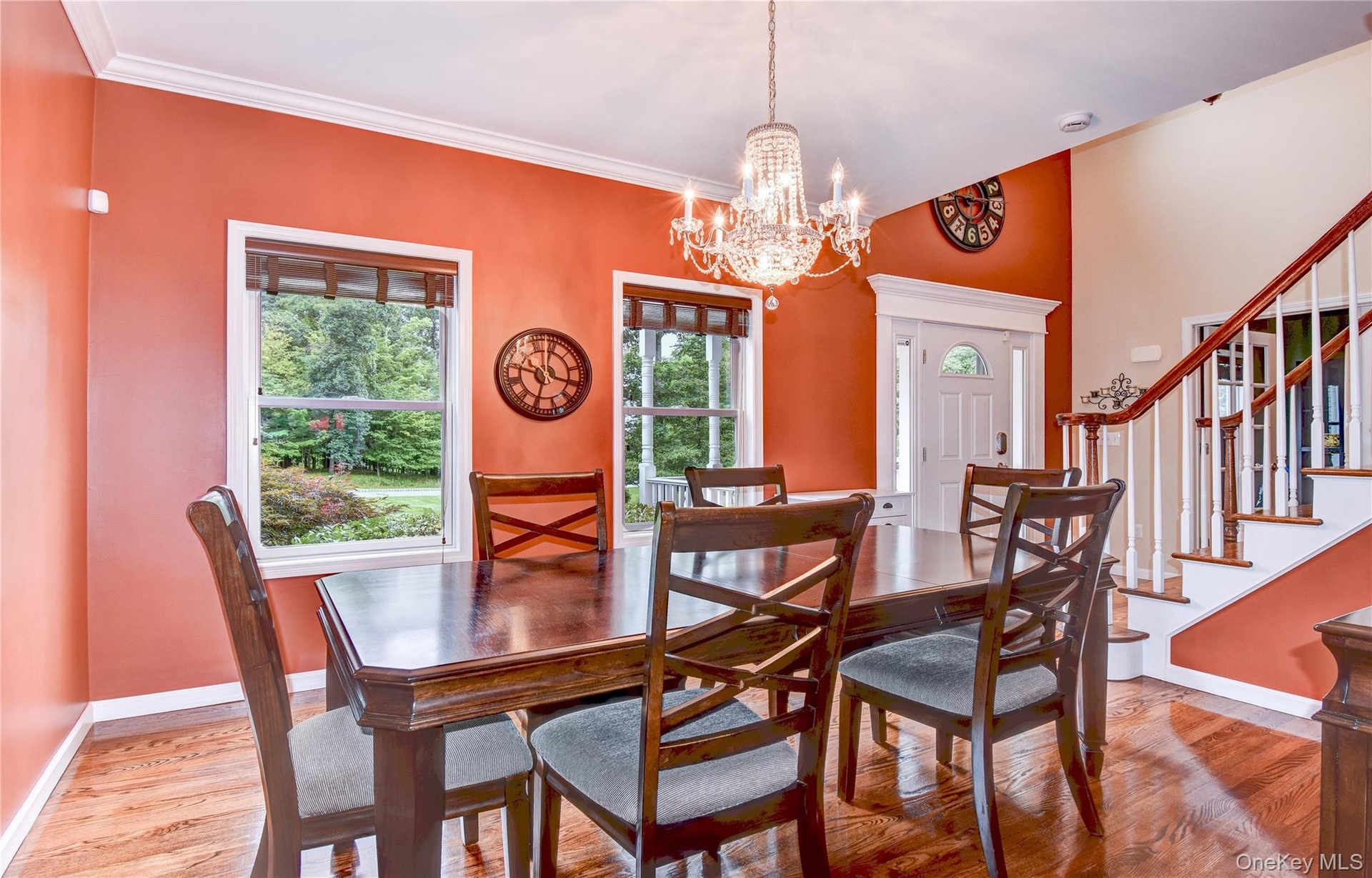 Dining space featuring wood  flooring, a crystal chandelier, and two large windows