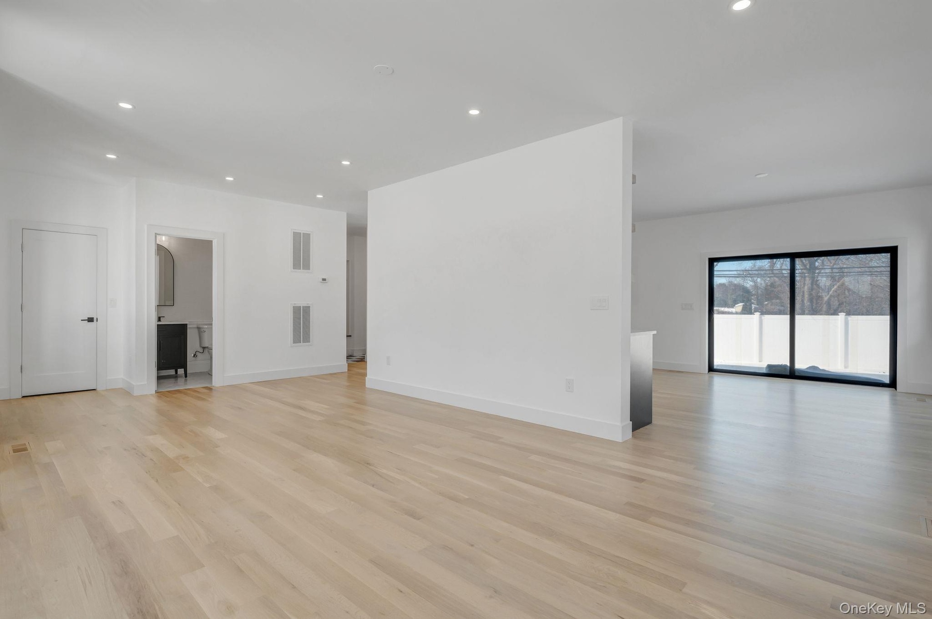 Spacious and open living area filled with natural sunlight from oversized windows, designed for both everyday comfort and entertaining.