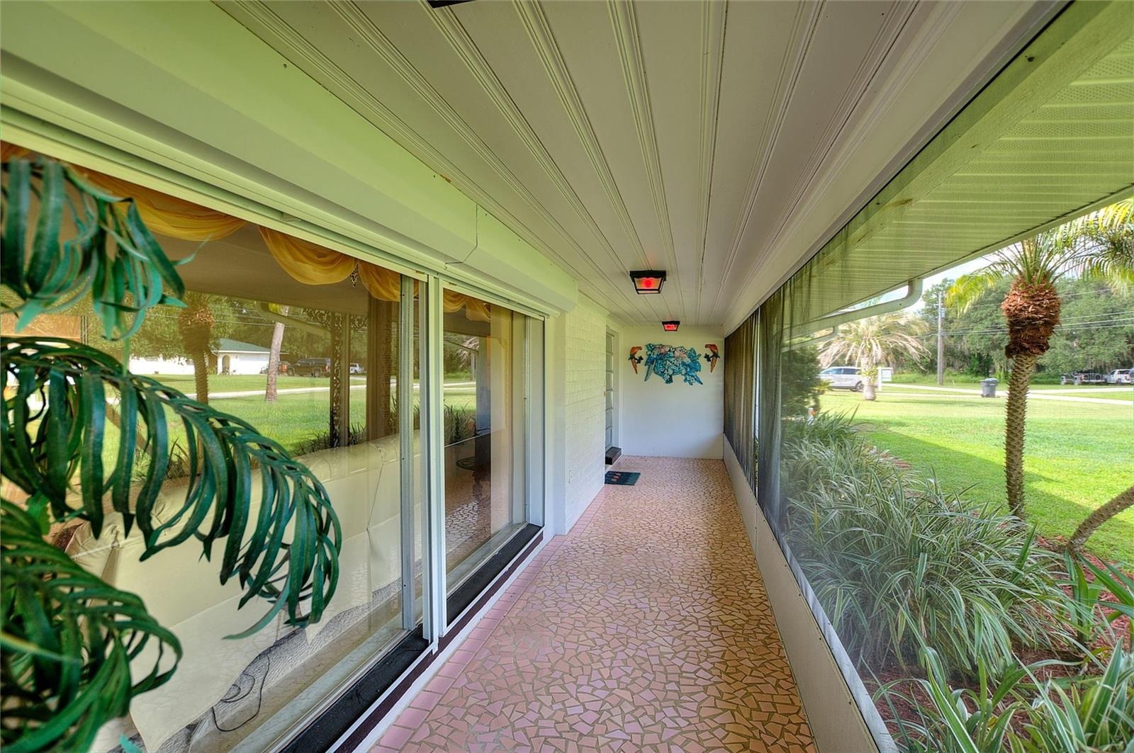 Beautiful porch with vintage broken tile.  There are hurricane shutters on the big front windows.