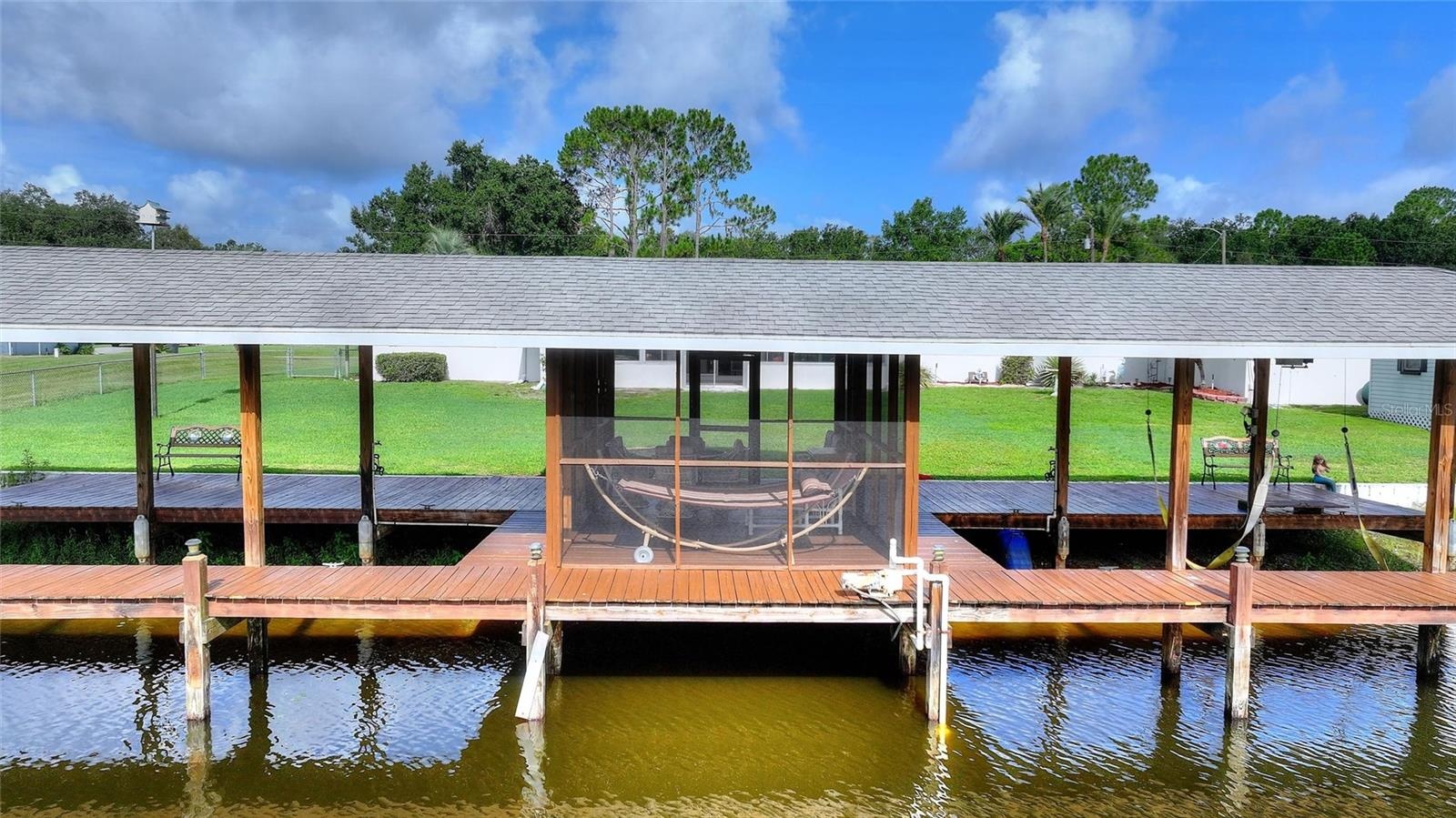 HUGE covered boathouse with screened room.  One side has a lift.