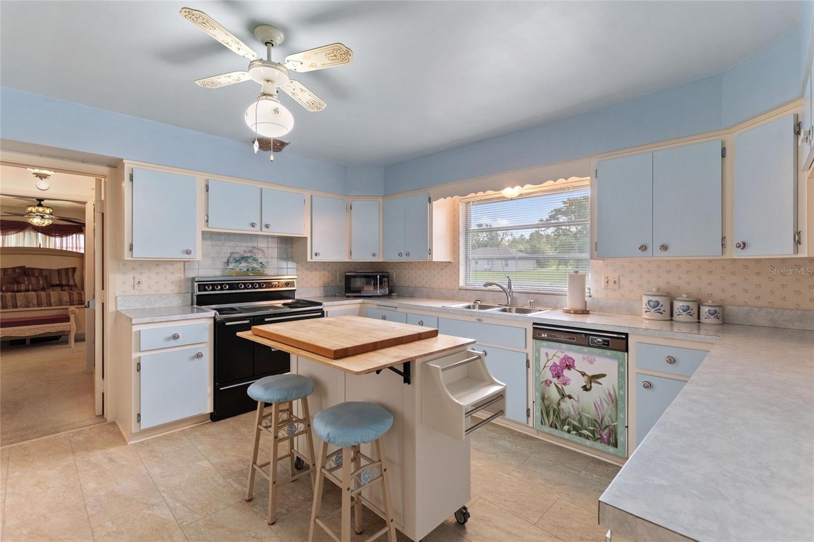 The kitchen is located right off of the formal dining room and has an entry into the informal areas.  The doorway in the rear of the picture leads int